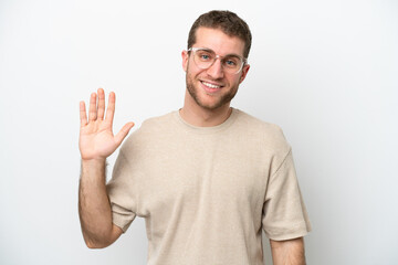 Fototapeta premium Young caucasian man isolated on white background saluting with hand with happy expression