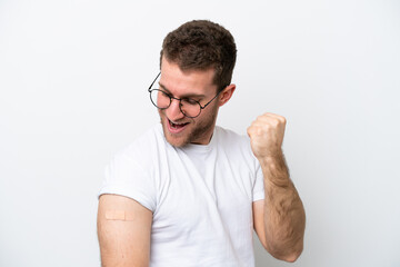 Fototapeta premium Young caucasian man wearing band aids isolated on white background celebrating a victory