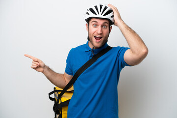 Young caucasian man with thermal backpack isolated on white background surprised and pointing finger to the side