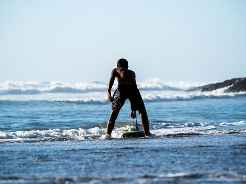Bodyboarder preparing to enter beach surf