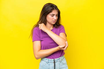 Young caucasian woman isolated on yellow background with pain in elbow