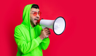 man announcer with loudspeaker isolated on red background, copy space. - obrazy, fototapety, plakaty