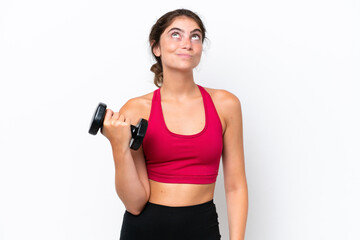Young sport caucasian woman making weightlifting isolated on white background and looking up