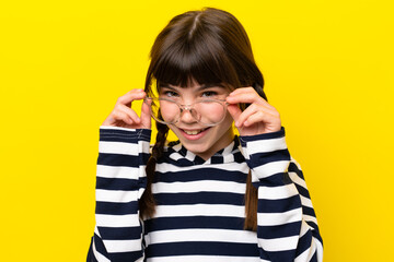 Little caucasian girl isolated on yellow background With glasses with happy expression