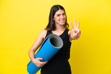 sport Italian woman going to yoga classes isolated on yellow background happy and counting three with fingers