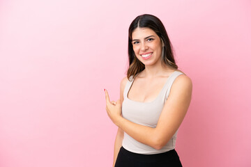 Young Italian woman isolated on pink background pointing back