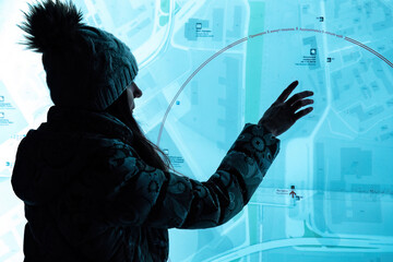 woman standing in front big digital screen with city street map