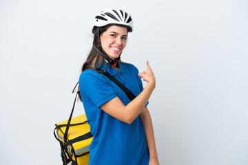 Young delivery woman with thermal backpack isolated on white background pointing back