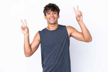 Young sport caucasian man isolated on white background showing victory sign with both hands