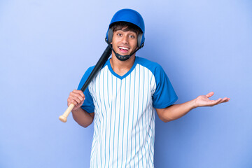 Baseball caucasian man player with helmet and bat isolated on blue background with shocked facial...