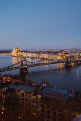 Night view of Budapest showcasing illuminated buildings, bridges, and reflections on the Danube River at dusk