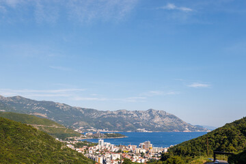 Fototapeta na wymiar Bird's eye view of towns of Budva and Becici with hotels and beaches near Adriatic Sea against the backdrop of the Montenegrin Mountains