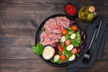 Lunch dish Roast beef with spinach salad and quail eggs healthy lunch keto diet food	