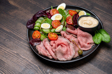 Lunch dish Roast beef with spinach salad and quail eggs healthy lunch keto diet food	