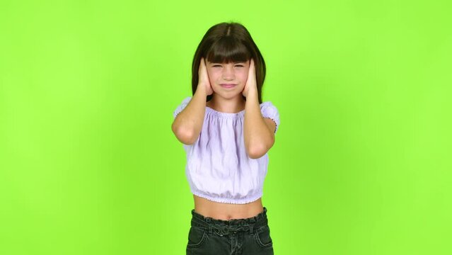 Little girl covering both ears with hands. Frustrated expression  over isolated background