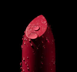 Close up red lipstick covered with water droplets. Red lipstick isolated on black background....