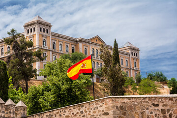 Provincial Palace of the Deputation and Spanish flag in the foreground - obrazy, fototapety, plakaty