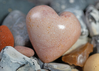 Herz aus Speckstein zwischen bunten Steinen