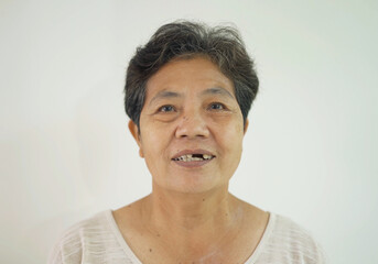 Portrait of old elderly Asian Thai woman smiling isolated on white background. People lifestyle. Senior grandmother. Patient in healthcare concept.