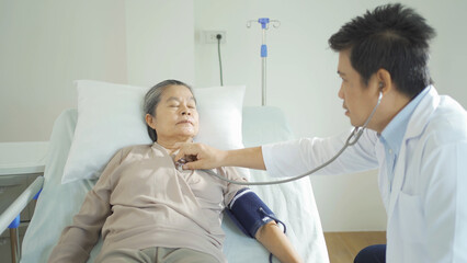 Obraz premium Portrait of Asian doctor check up body of sick old senior elderly patient on bed in hospital in medical and healthcare treatment at nursing home. People lifestyle