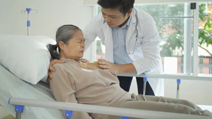 Portrait of Asian doctor check up body of sick old senior elderly patient on bed in hospital in medical and healthcare treatment at nursing home. People lifestyle