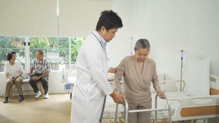 Fototapeta premium An Asian doctor with a group of old elderly patient or pensioner in nursing home in hospital. Senior people lifestyle activity recreation. Health care physical therapy.