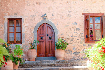 Fototapeta na wymiar Wood door and windows with wooden shutters on pink colored wall