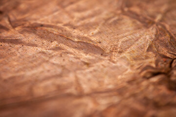 Extreme closeup of crumpled brass foil texture