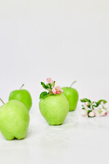 Apple flowers and ripe green apples on a white background, Fruits and flowers, sping concept. Top view