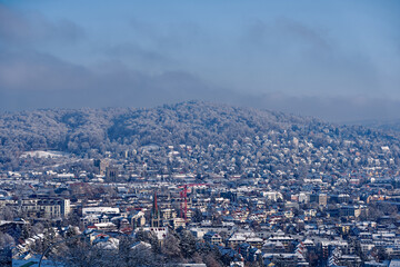 Scenic aerial view over snow covered City of Zürich with skyline and residential area on a blue cloudy late autumn day. Photo taken December 11th, 2022, Zurich, Switzerland.