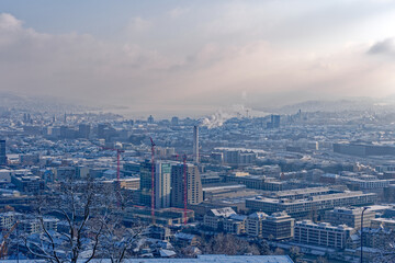 Aerial view over snow covered City of Zürich with Lake Zürich in the background on a blue cloudy late autumn day. Photo taken December 11th, 2022, Zurich, Switzerland.
