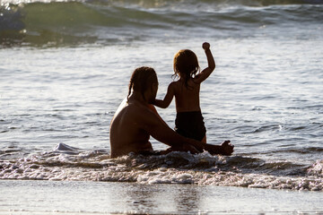 Father and little son waiting for wave - obrazy, fototapety, plakaty