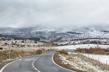Provincial asphalt road in the countryside against the backdrop of mountains in winter.