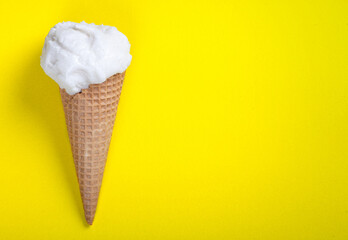 Waffle cone with ice cream on yellow background