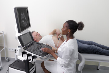 An African-American Doctor Examines A Male Patient with an Ultrasound Machine