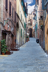 At the narrow streets in the old town of Siena, Italy