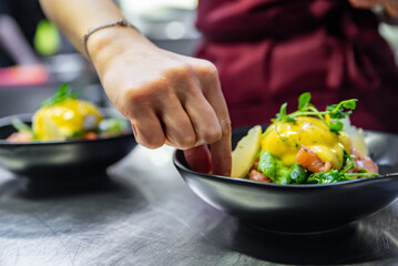 Chef in restaurant kitchen cooking salad 