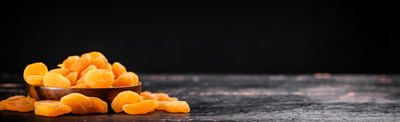 Full wooden plate with dried apricots. 