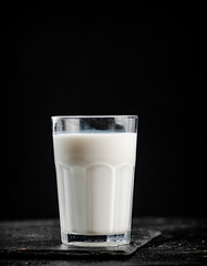 A glass of fresh milk on a stone board. 