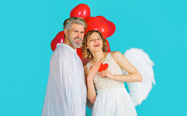 Lovely Valentines day couple. Smiling woman with red paper heart and man with heart shaped balloons.