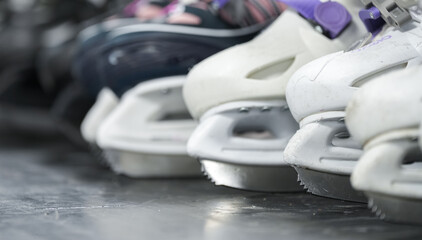A lot of ice skates. Close-up view of the sharp blade of some ice skates used by children. Ice skating as a hobby sport for children.