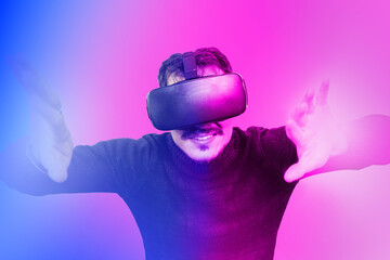 Young man is using virtual reality viewer. Modern man portrait with trendy look and bright colors.