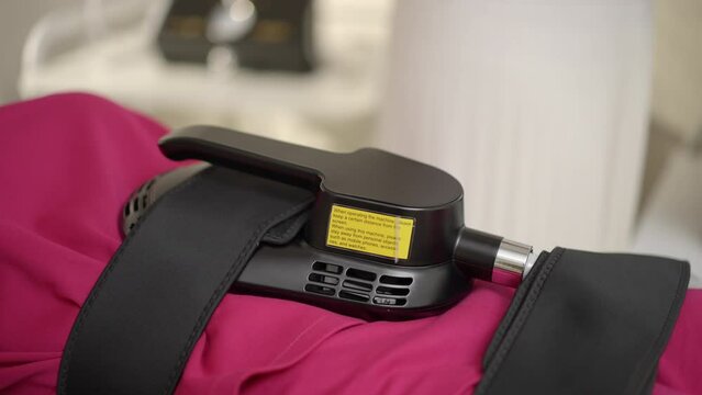 Young female receiving ems treatment on her abdomen to burn fat and build muscles