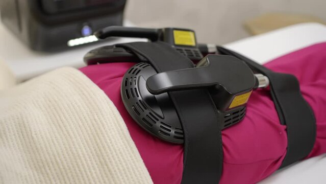 Close-up view of a young woman getting ems treatment on her buttocks to burn fat and build muscles and remove cellulite