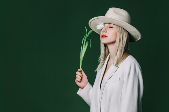 Stylish blond hair woman with tulip flower on green background