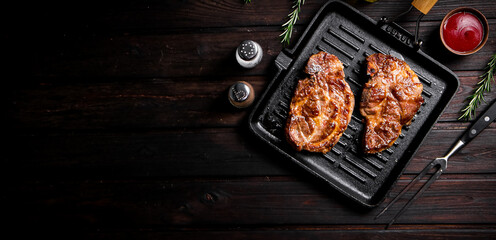 Grilled pork steak in a frying pan. 