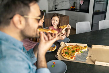 Happy family eating pizza  at home