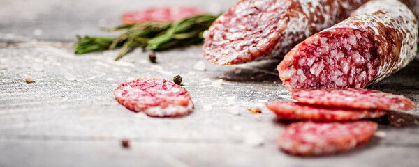 Pieces of salami sausage with sprigs of rosemary. 