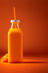 Frisch gepresster Orangensaft in einer Flasche isoliert auf orangenen Hintergrund - Generative Ai