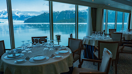 Empty restaurant seats interior by panoramic windows at scenic glacier bay nature view